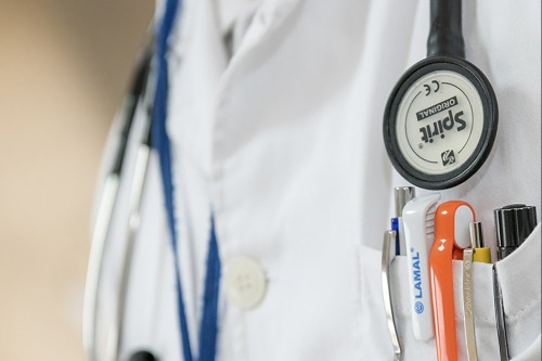 white coat, stethoscope, and pens